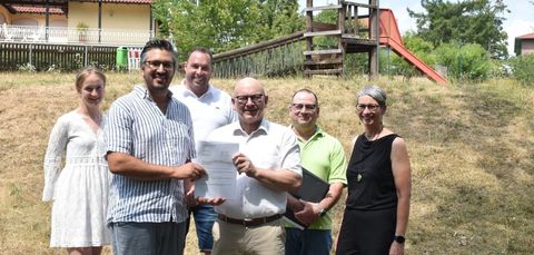 „Gut investiertes Geld“: Auf dem Spielplatz Am Hexenberg übergibt Landrat Frank Matiaske (dritter von rechts) Bürgermeister Matthias Horlacher den Förderbescheid für die Neugestaltung des Areals. Mit ihnen freuen sich (von links) Ariane Ehrhardt und Jens