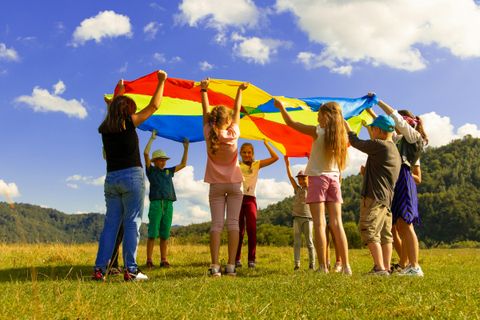 Kinder spielen mit einem bunten Tuch